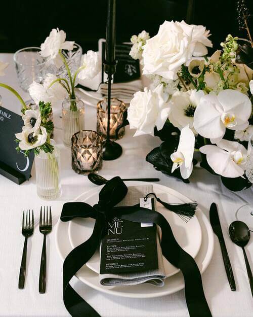 Black and white themed wedding table setting with menu