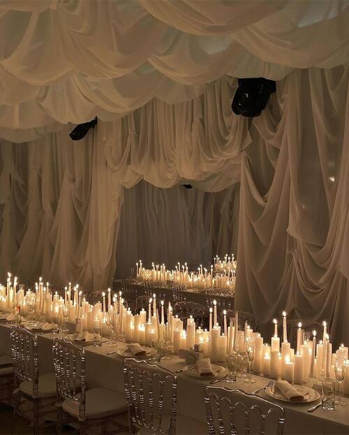 Black and white themed wedding white table setting with draped material and candles