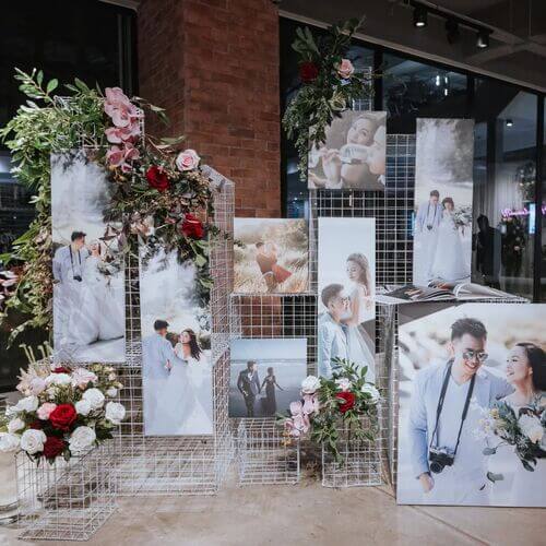 Photo display at wedding with floral arrangements