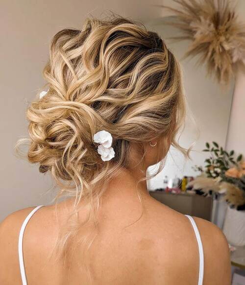 Wavy up-do with floral hairpin bridal hairstyle