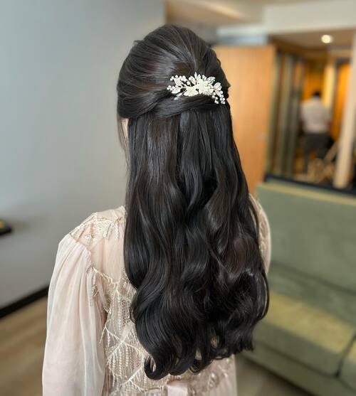 Half up half down with floral hairclip bridal hairstyle