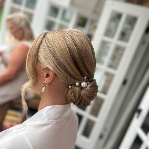 Low slicked back bun with pearl hairclips