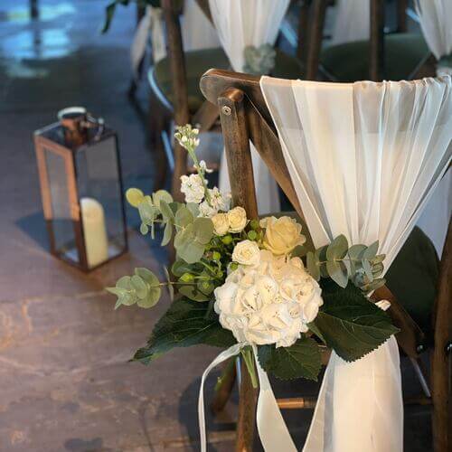 White and creme flower wedding chair decor