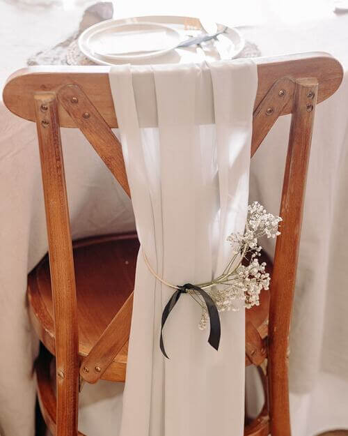 Wedding chair decor using a gold ring and baby's breathe