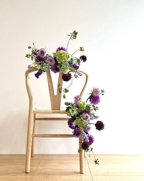 Explosion of purple wedding chair decor with floral arrangement