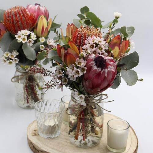 Rustic wedding table center piece proteas and eucalyptus leaves