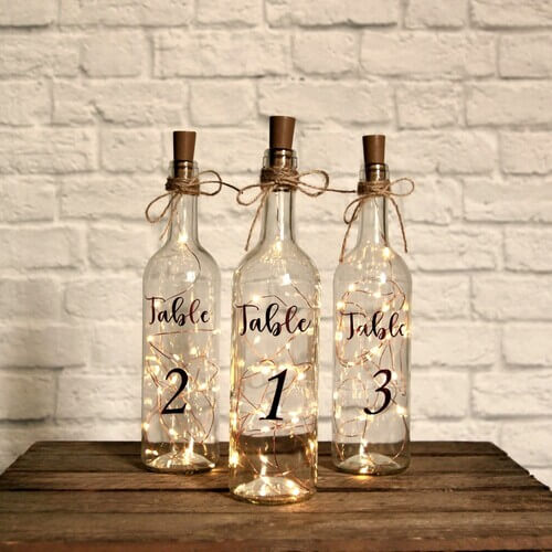 Rustic wedding table center piece wine bottles and fairy lights