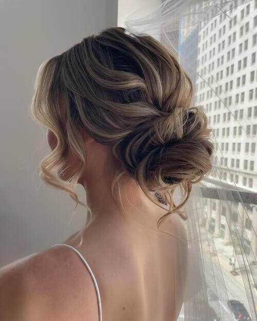 Low curly hair bun romantic wedding hairstyle