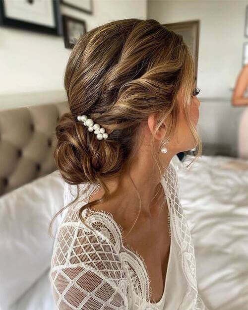 Low bun with hair piece romantic wedding hairstyle