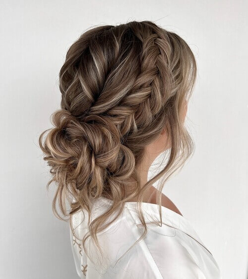 Fish braid and low bun romantic wedding hairstyle 