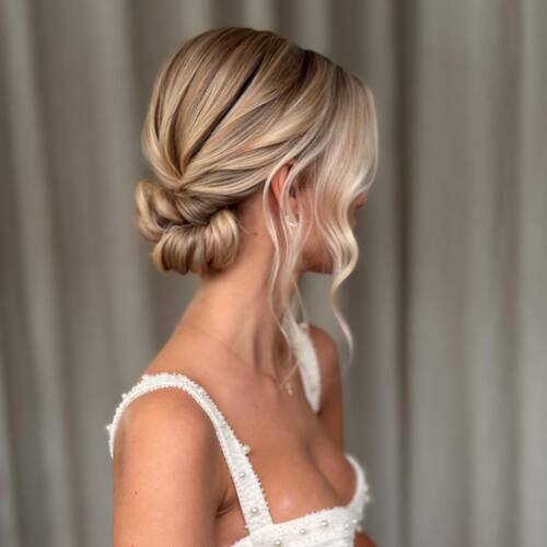 Low bun with side pieces romantic wedding hairstyle