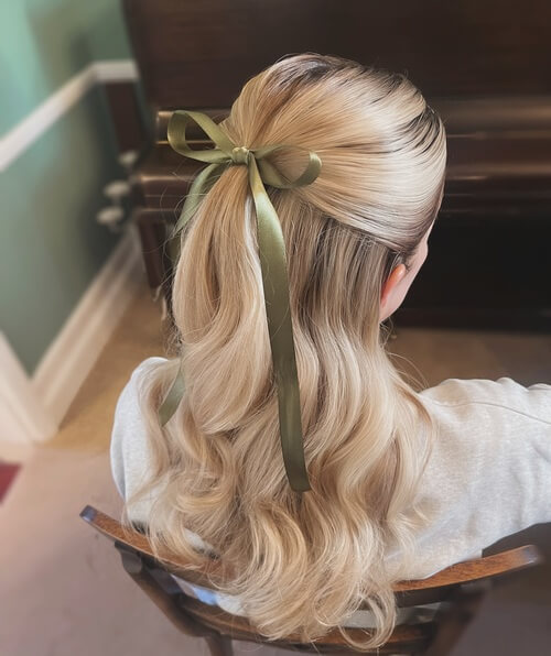 Sleek Half up, half down romantic wedding hairstyle with a bow